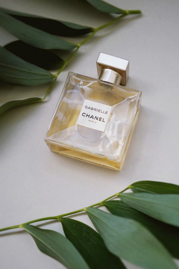 Image of a parfum bottle with leaves on a table